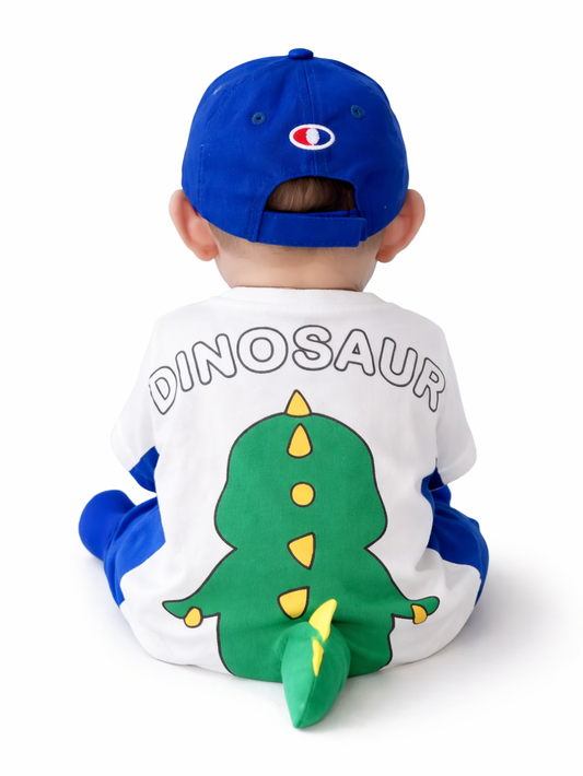 白背景で後ろ向きに座る赤ちゃん。青いキャップをかぶり、背中に「DINOSAUR」の文字と大きな緑の恐竜イラスト（立体しっぽ付き）が入った白×青のベビー服を着ている。
