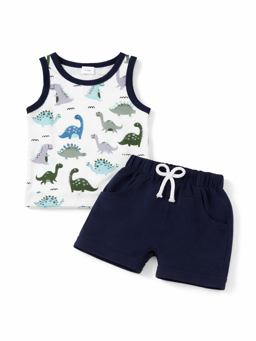 白背景に平置きされたキッズ用2点セット。ネイビーの縁取りがある恐竜柄の白いタンクトップと、白い紐付きウエストのネイビーショートパンツが並べられている。全体が明るくクリアに写っている。
