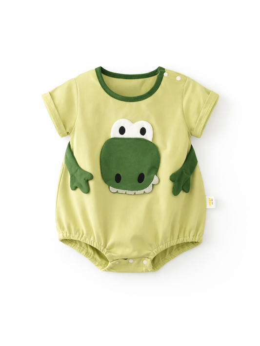 淡いライトグリーンのベビーロンパース（半袖）。胸元に恐竜の顔の立体アップリケが付いており、白い背景の上に平置きで撮影されている。
