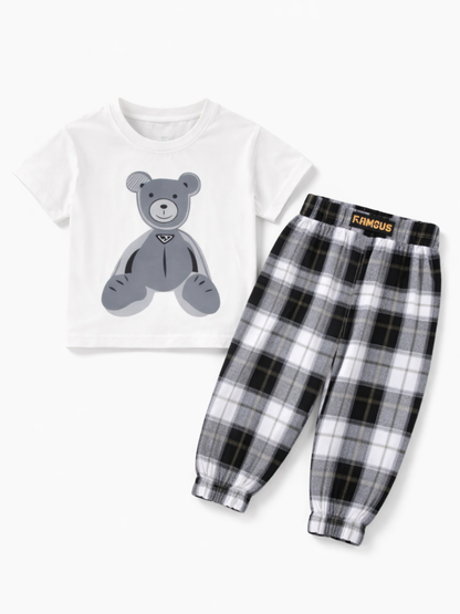 白い半袖Tシャツ（グレーのくまプリント）と、白・黒・グレーのチェック柄ジョガーパンツの子ども用上下セットを、純白の背景で平置き撮影した商品画像
