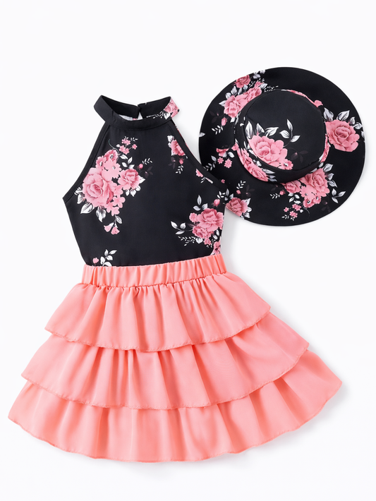 黒地にピンクの花柄ホルターネックワンピース（ピーチピンクのティアードスカート）と、同柄のつば広ハットの女の子用2点セットを、純白の背景で平置き撮影した商品画像
