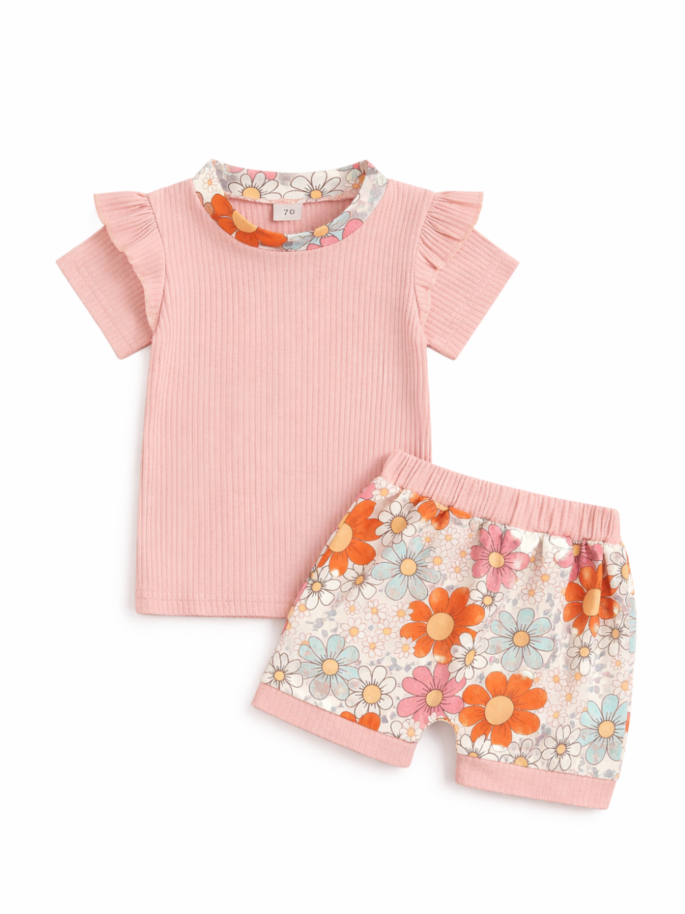 ベビー用の半袖トップスとショートパンツの2点セット。淡いピンクのリブ素材トップスはフリル袖で、花柄の襟ぐりデザイン。ショーツはレトロ調の花柄プリント（オレンジ・ピンク・ブルー系）で、ウエストと裾にピンクのリブ切替。白背景のスタジオ撮影で上下を並べて見せている。
