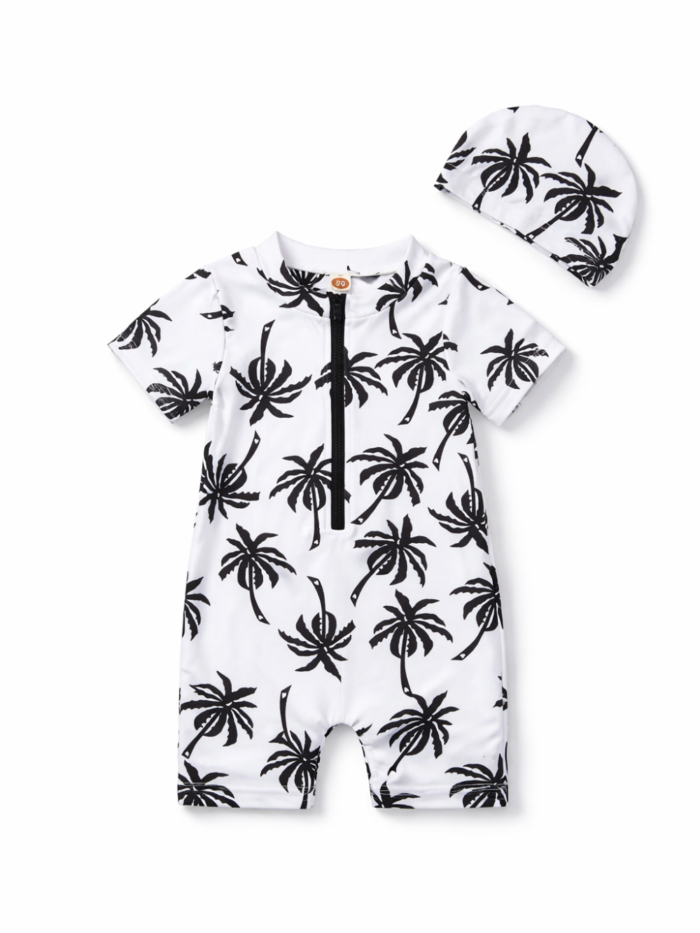 ベビー用の半袖ロンパース水着とスイムキャップの2点セット。白地に黒のヤシの木プリントで、前面に黒いハーフジップ付き。おそろい柄のキャップが付属。白背景のスタジオ撮影で上下を並べて見せている。

