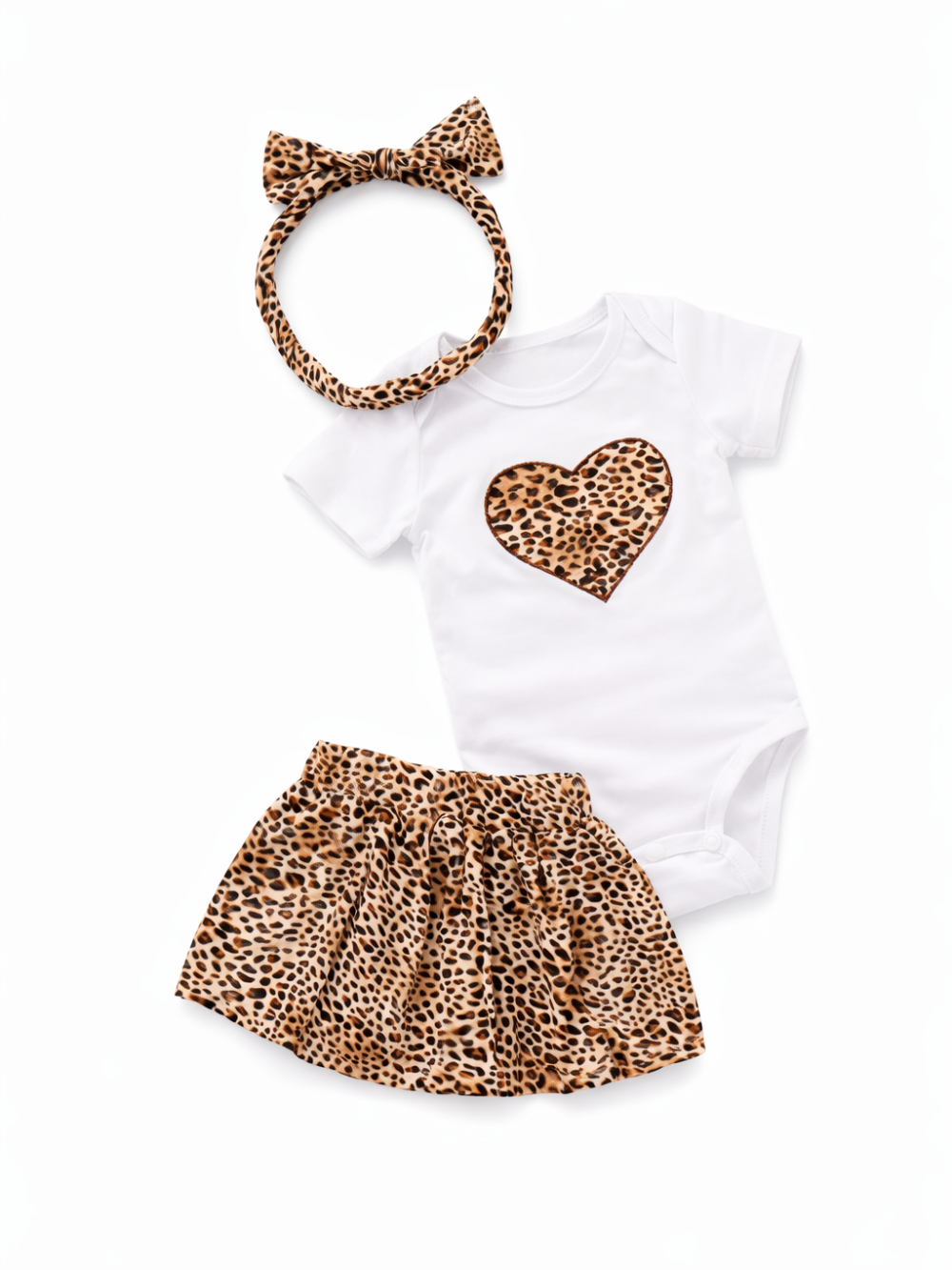 ベビー用の3点セット。白い半袖ロンパースにヒョウ柄ハートのアップリケ、ヒョウ柄のフレアスカート、同柄のリボン付きヘアバンドを白背景に平置きで撮影しています。
