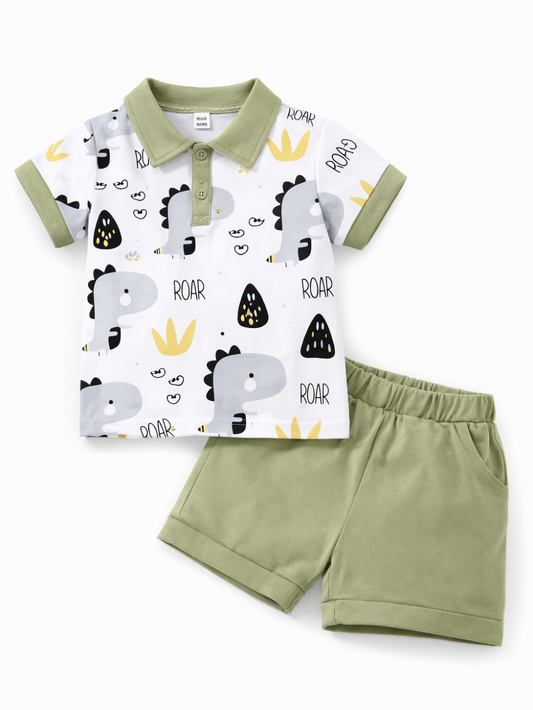 キッズ用のポロシャツとショートパンツの2点セット。白地のポロシャツに恐竜イラストと「ROAR」柄、襟と袖口はカーキ色。カーキ色のショーツはウエストゴムで、白背景に平置き撮影されています。
