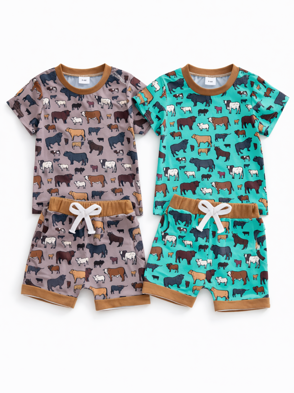 キッズ用の半袖Tシャツ＆ショートパンツの2セットを並べた商品画像。左はグレージュ、右はターコイズの地色に牛の総柄プリントで、襟・ウエスト・裾はブラウン。白い紐付きウエストで、白背景に平置き撮影されています。
