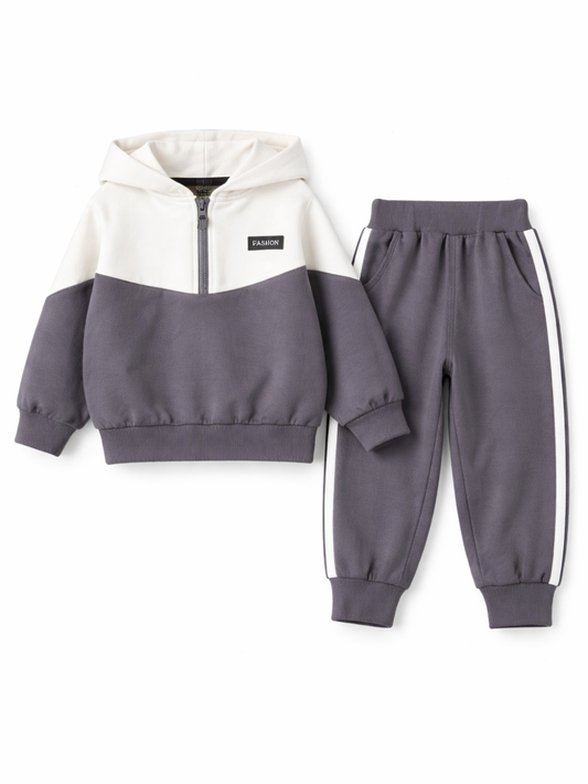白背景で撮影したキッズ用スウェット上下セットの商品写真。ホワイト×チャコールの配色ハーフジップパーカーと、サイドライン入りチャコールのジョガーパンツが並んでいる。
