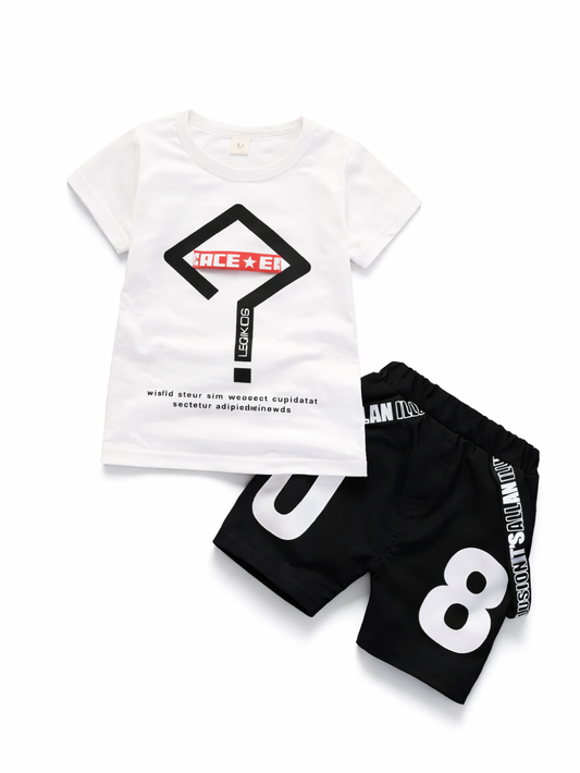 白い半袖Tシャツ（黒×赤のサイン風ロゴプリント）と、黒のショートパンツ（大きな「8」プリント）のキッズ2点セットを、上から撮影した商品画像。Tシャツは左上、パンツは右下に斜め配置。白背景で輪郭がくっきり見える。
