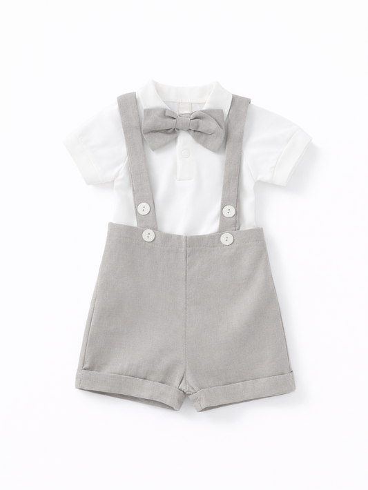 白の半袖ポロシャツにグレーの蝶ネクタイ、ライトグレーのサスペンダー付きショートパンツを組み合わせたベビー用フォーマルセットの正面商品画像（白背景）。
