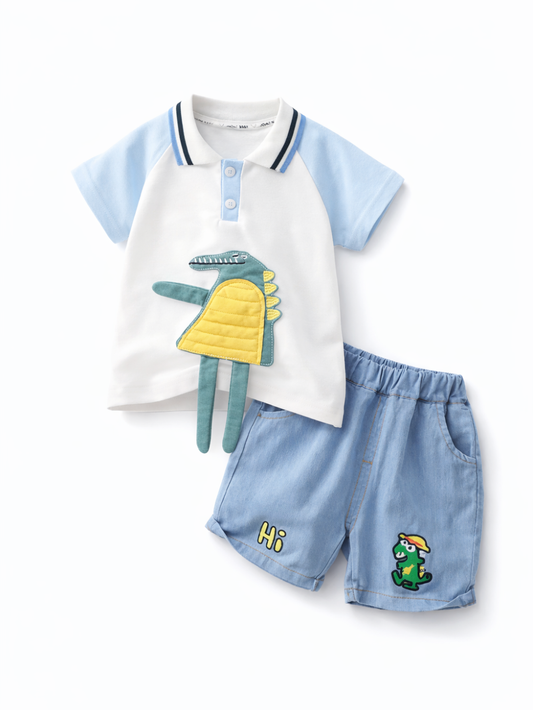 白×水色のラグランポロ風トップスとライトデニムのショートパンツのキッズ上下セット。トップス前立てはボタン付きで、胸元に立体ワニアップリケ（グリーン×イエロー、脚が垂れるデザイン）。パンツには「Hi」ロゴと小さな恐竜プリント入り。白背景で上下を並べて撮影した商品画像。
