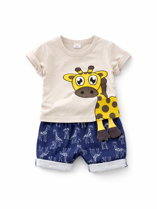 キッズ用の上下セット。ベージュの半袖Tシャツに、黄色いキリンの大きなプリント（立体風デザインで脚が垂れる仕様）。ネイビーのショートパンツは白いキリン柄プリント入りで、裾はロールアップ。白背景のスタジオで上下を中央に配置して撮影した商品画像。
