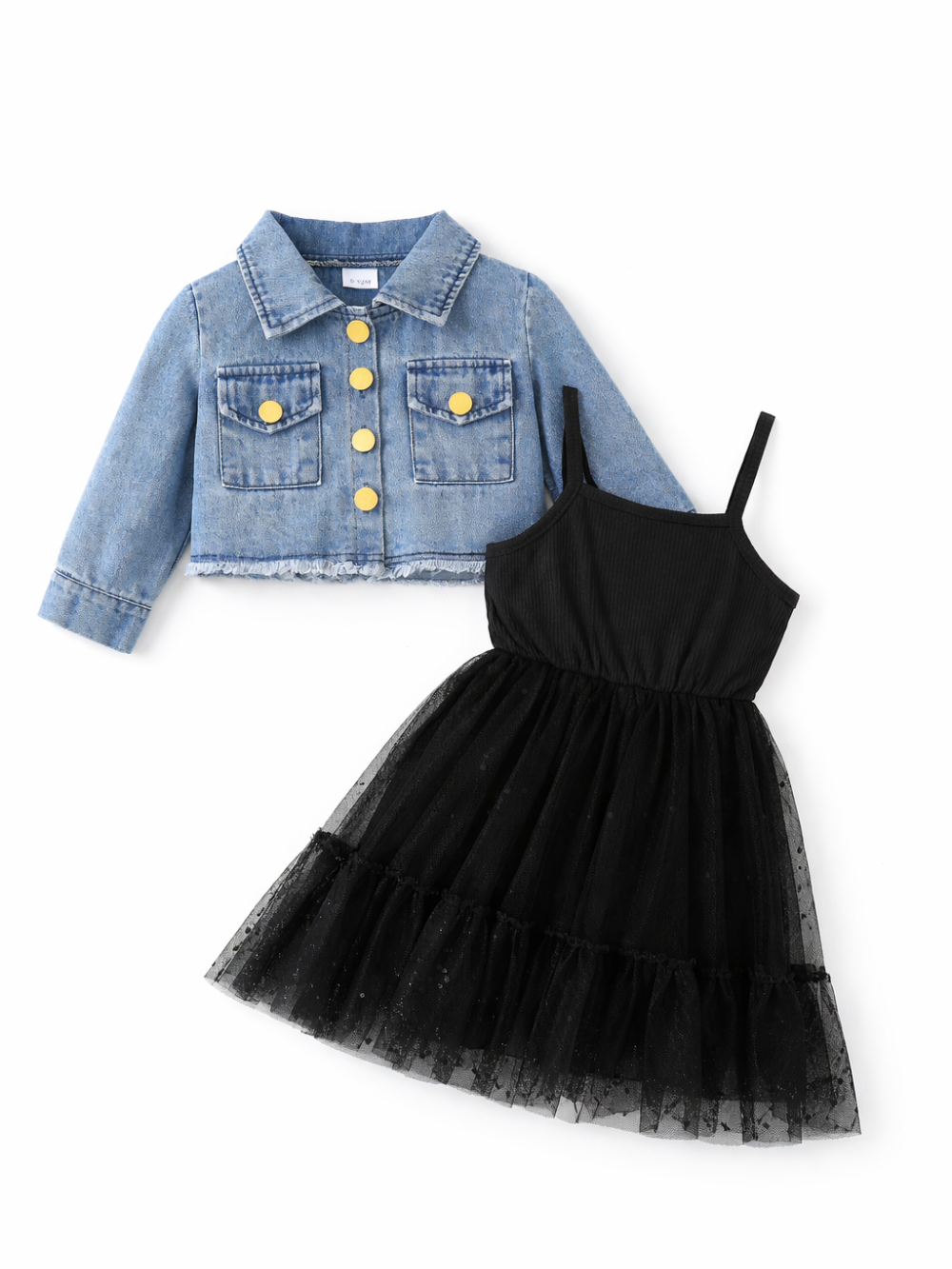 白背景のスタジオ撮影で、ライトブルーのショート丈デニムジャケットと黒のチュールワンピースのキッズ2点セットが平置きで配置されている。ジャケットはフリンジ裾とゴールドボタン付き、ワンピースはキャミソール型でティアードのチュールスカートになっている。
