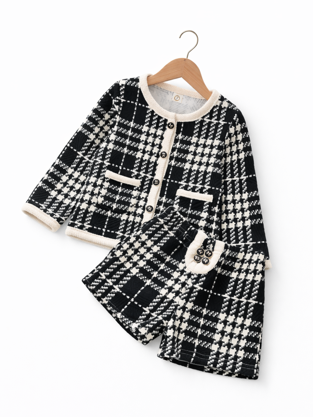 白い背景に、黒×白のチェック柄ツイード風カーディガンとおそろいのショートパンツをハンガーで並べた子ども用2点セット。
