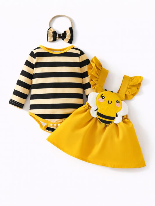ハチモチーフのベビー女の子3点セット。黒×イエローのボーダー長袖ロンパース、ハチのアップリケ付きイエローワンピース（フリル肩紐）、ボーダーリボンのヘアバンドのセット。白背景のスタジオ撮影。

