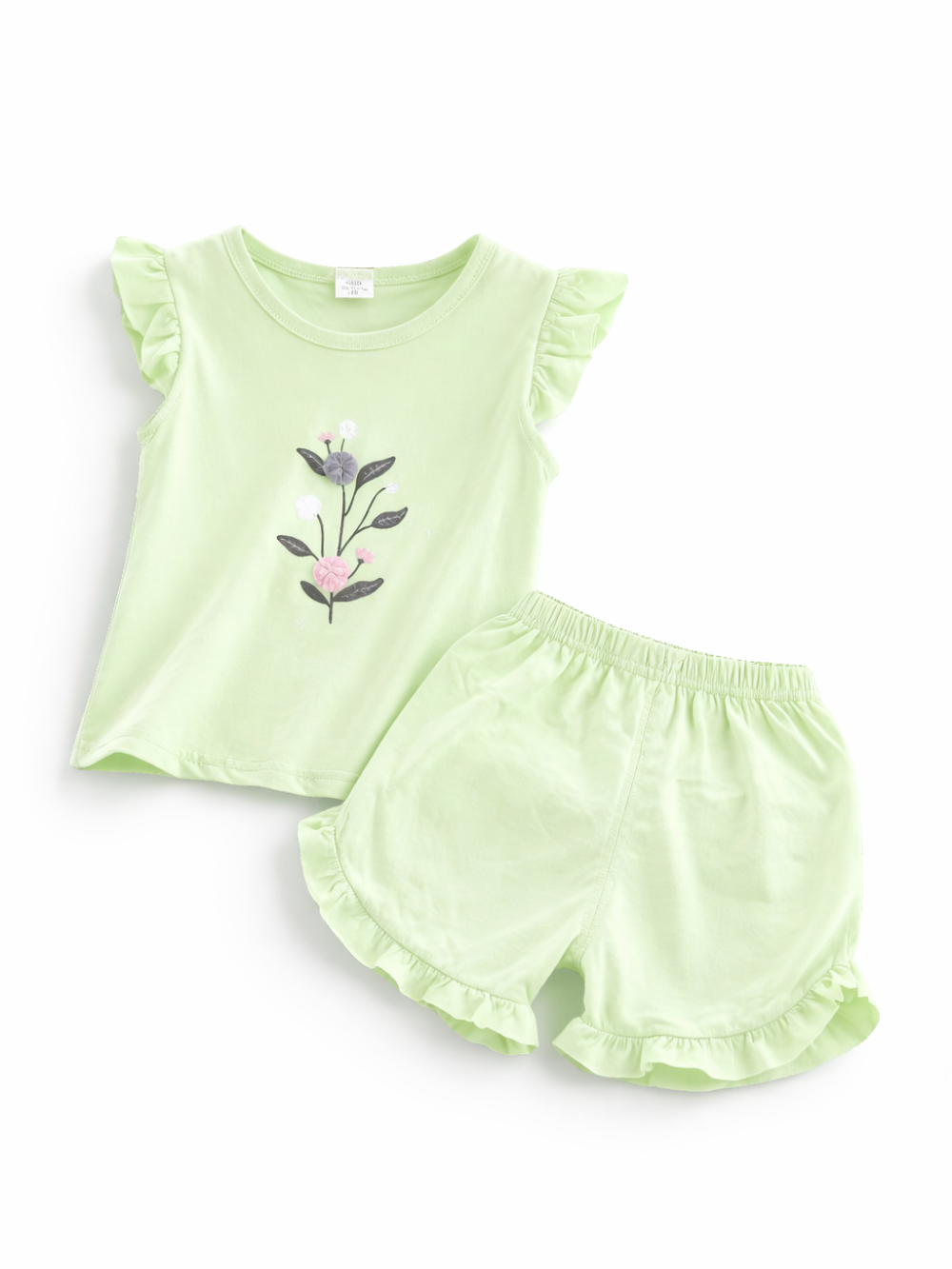 ライトグリーンのキッズ上下2点セット。フリル袖のノースリーブトップスに立体的な花の刺繍モチーフ付きで、ボトムはウエストゴムのフリル裾ショートパンツ。白背景のスタジオ撮影。
