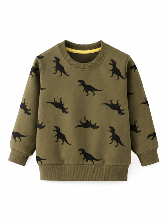 白背景の正面写真。カーキ（オリーブ）色の子ども用スウェット（長袖）。黒の恐竜（Tレックス）シルエット総柄プリント、リブ襟・袖口・裾、首元にイエローの内側パイピング。
