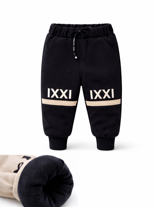 キッズ用裏起毛ジョガーパンツ（ブラック）。ウエストはゴム＋ドローストリング仕様で、裾はリブ。膝付近に「IXXI」ロゴと配色ラインが入ったデザイン。別カットで、裾口のやわらかな裏起毛（フリース）素材の厚みと質感をクローズアップで確認できます。
