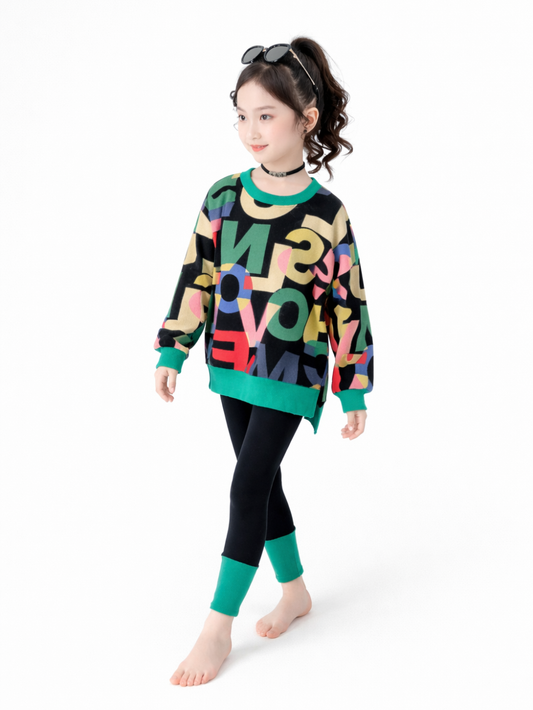カラフルなレタープリントのオーバーサイズスウェットと、ブラックレギンス（グリーンの切替リブ付き）の女の子用2点セット。ストリート感のあるカジュアルコーデ。
