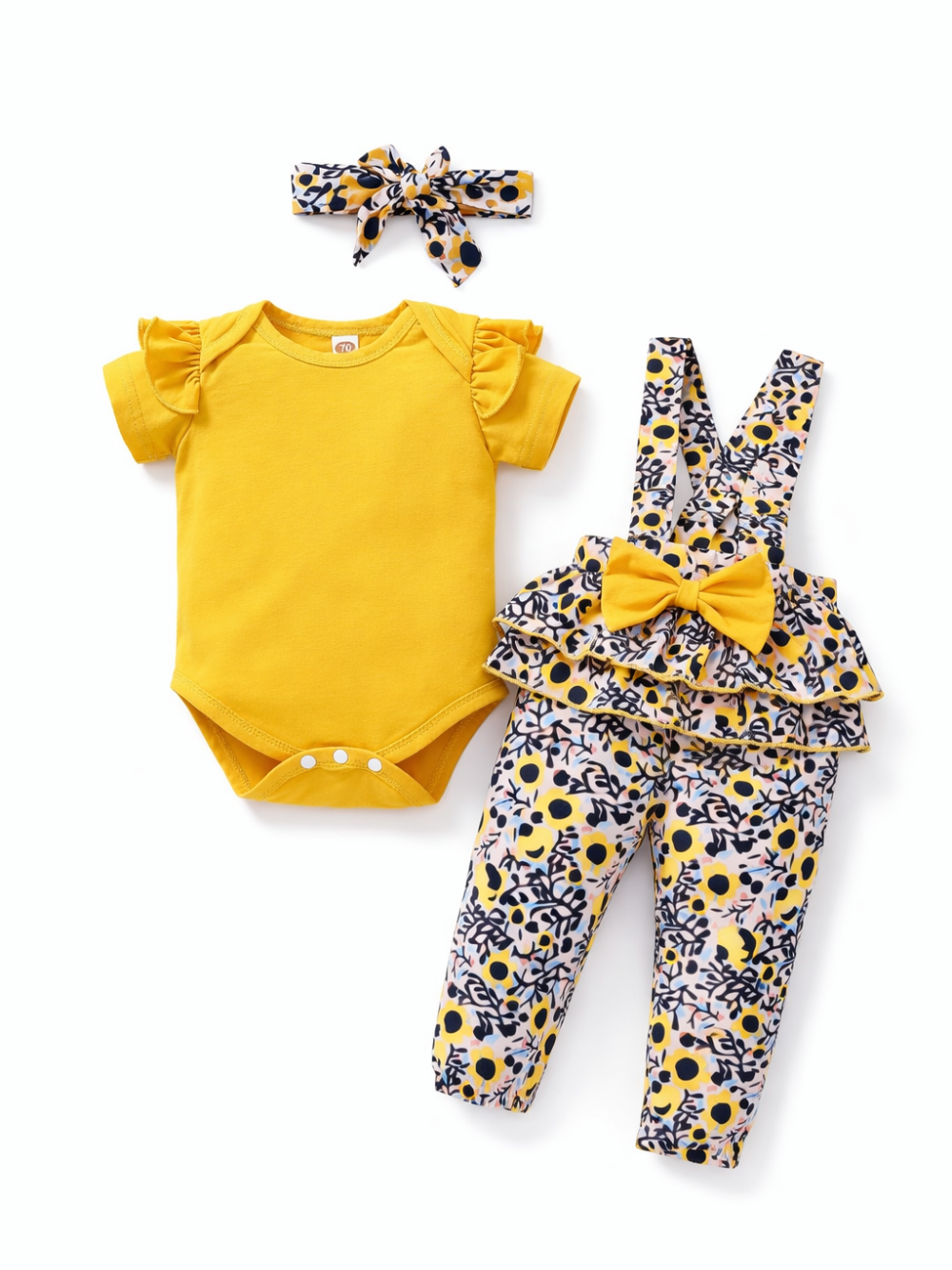 ベビー用3点セット：イエローのフリル袖ボディスーツ、花柄サスペンダーパンツ（大きなリボン付き）、おそろい花柄リボンヘアバンド。明るく可愛いコーデ。
