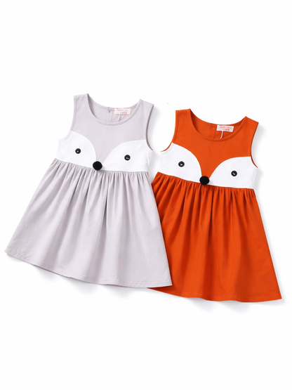 キツネ顔デザインのガールズノースリーブワンピース2色（グレー／オレンジ）。胸元に白いフェイス切替とボタン目、ポンポン鼻付きで可愛いフレアシルエット。
