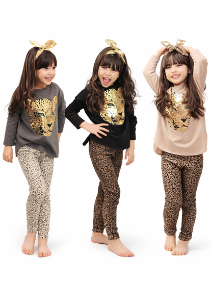 白いスタジオ背景で撮影した、キッズ用レオパード柄コーデの着用イメージ。女の子モデルが3パターン（グレー／ブラック／ベージュのトップス）を着用し、胸元にゴールドのヒョウ顔プリント、ボトムはレオパード柄レギンス。ヘアアクセ付きでポーズ違いの比較カタログ写真。
