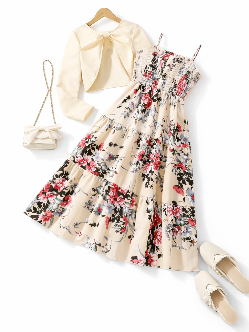 ベージュ地の花柄ティアードワンピースと、リボン結びのクリーム色ボレロカーディガンの2点セット。シャーリング胸元のキャミワンピースは多段フレアで華やかなデザイン。
