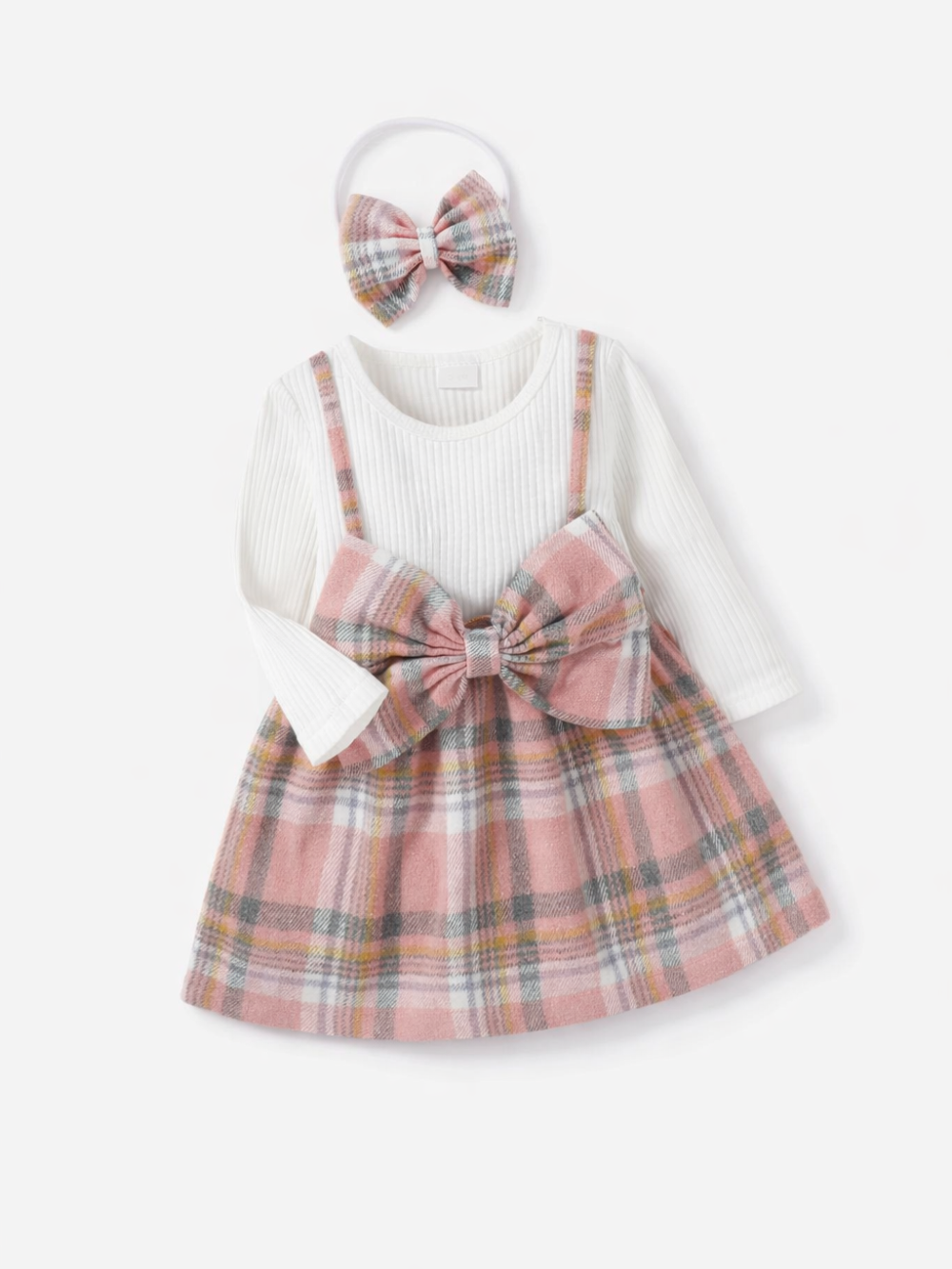 ベビー用チェック柄ジャンパースカート＋リブ長袖トップス＋リボンヘアバンドの3点セット。ピンク系チェックに大きなフロントリボン、白のリブトップスで上品に着映え。秋冬の普段着やお出かけに。
