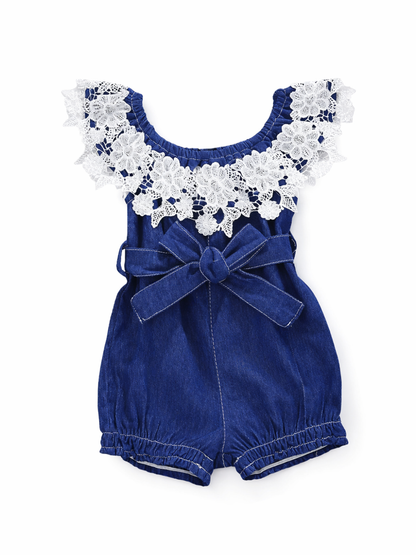 ベビー女の子用デニムロンパース商品画像。ネイビーデニムのショート丈ロンパースに白レースのフリル襟とウエストリボンをあしらったデザインを、白背景で撮影したカタログ写真。