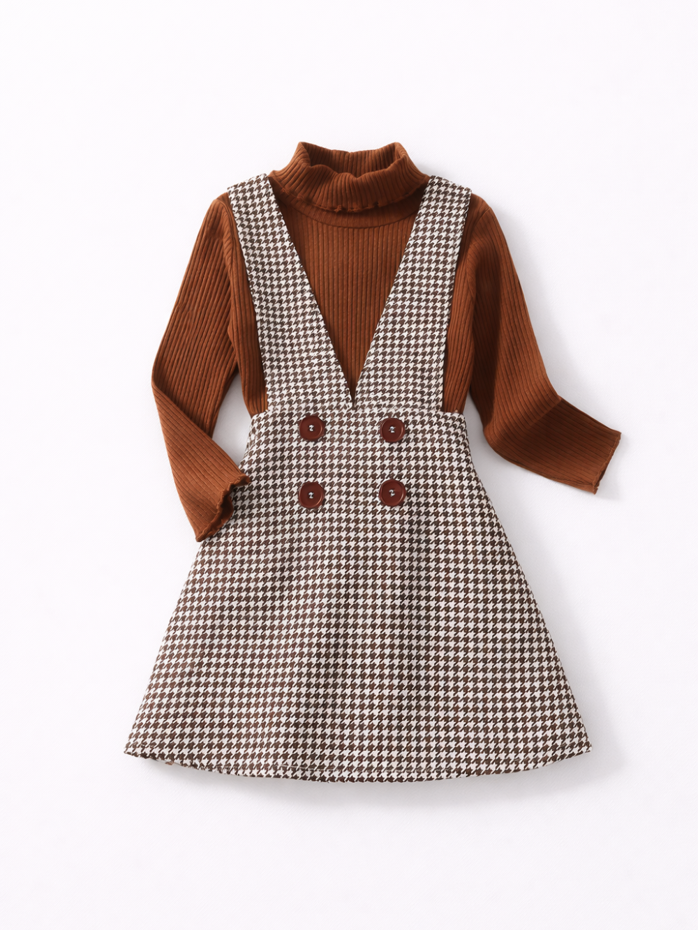 白背景にフラットレイで撮影した子ども用コーディネート。ブラウンのリブタートルネック長袖トップスと、千鳥格子柄のジャンパースカート（ダブルボタン付き）のセット。