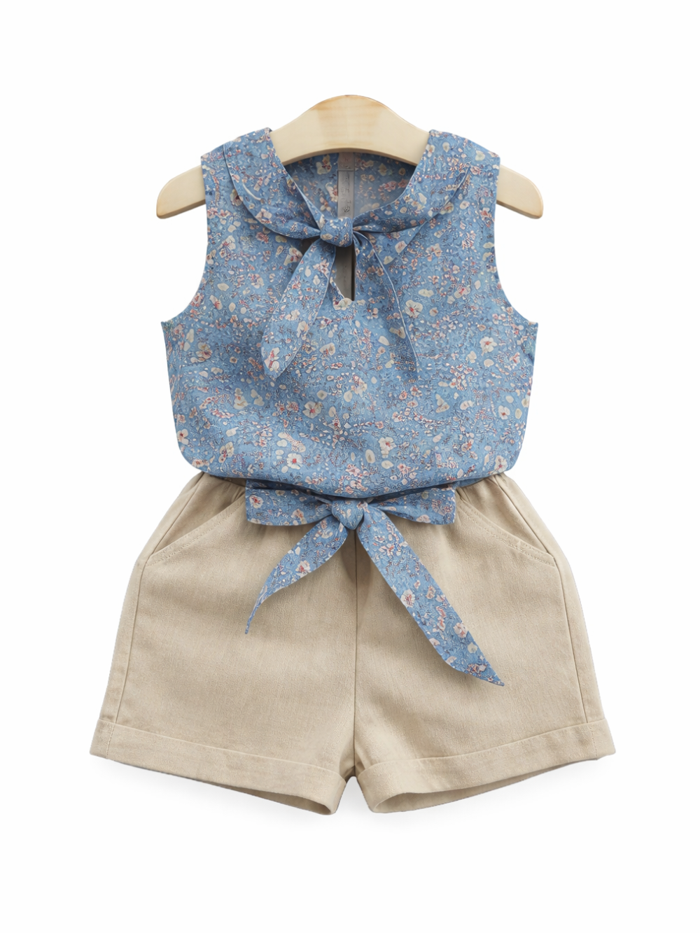 ガールズ用2点セット（花柄ノースリーブトップス＋ショートパンツ）。ブルーの小花柄リボントップスとベージュのショートパンツをハンガー掛けで撮影した商品画像。