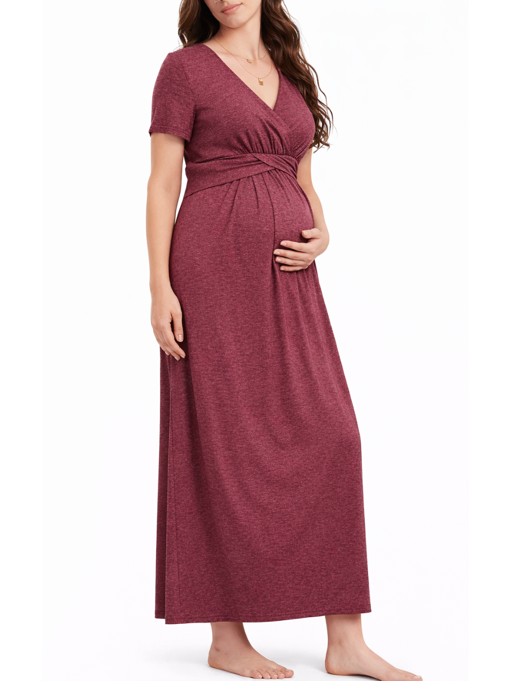 白背景のマタニティワンピース着用イメージ。日本人妊婦モデルが、ワインレッドのVネック半袖ロングワンピース（胸下切替・クロスデザイン）を着用し、お腹に手を添えて立ち姿でシルエットを見せている。
