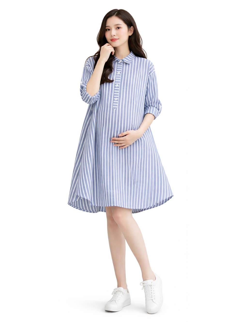 白背景のマタニティワンピース着用イメージ。日本人妊婦モデルが、ブルー×ホワイトのストライプ柄シャツワンピース（襟付き・前立てボタン・七分袖・Aライン・後ろ下がりの裾）を着用し、お腹に手を添えてカタログ風ポーズで立っている。