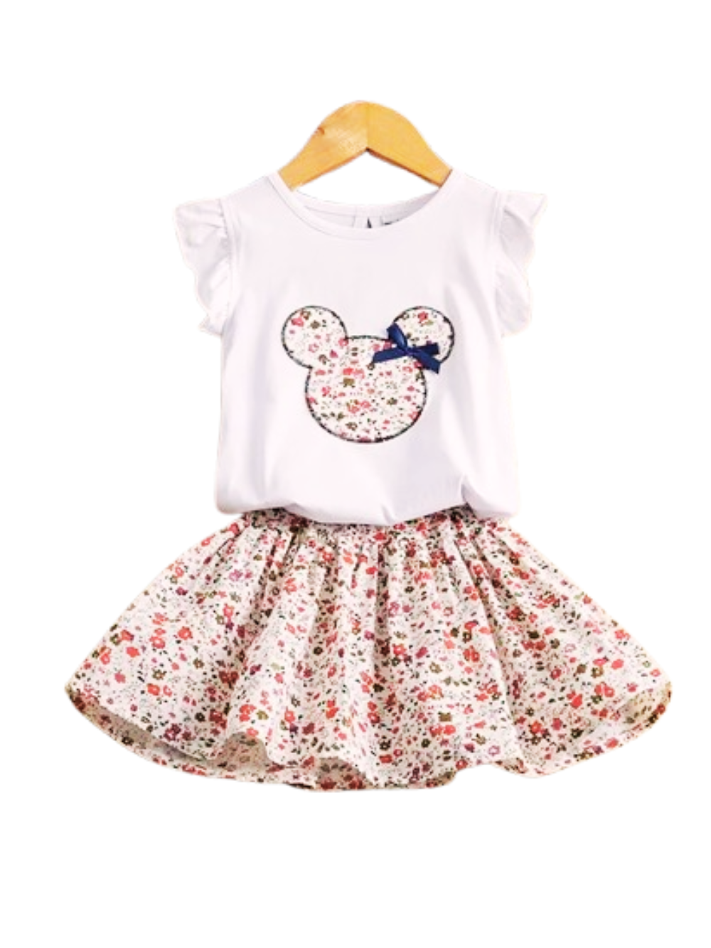 白背景に、キッズ用の白いフリル袖トップスと花柄スカートの2点セット。トップス中央に花柄の丸耳シルエット刺繍とネイビーのリボンが付いている。
