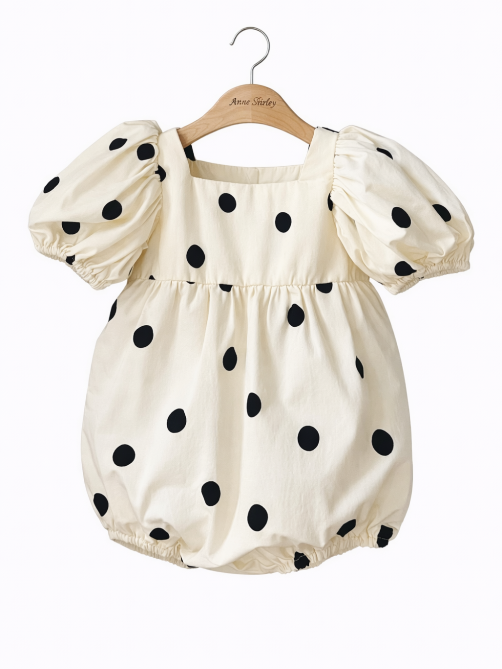 ハンガーに掛けたドット柄パフ袖ボディスーツの正面デザイン
