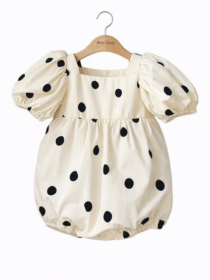 ハンガーに掛けたドット柄パフ袖ボディスーツの正面デザイン
