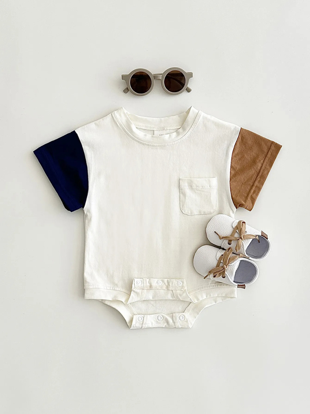 ベビー用半袖ボディスーツのフラットレイ正面イメージ
