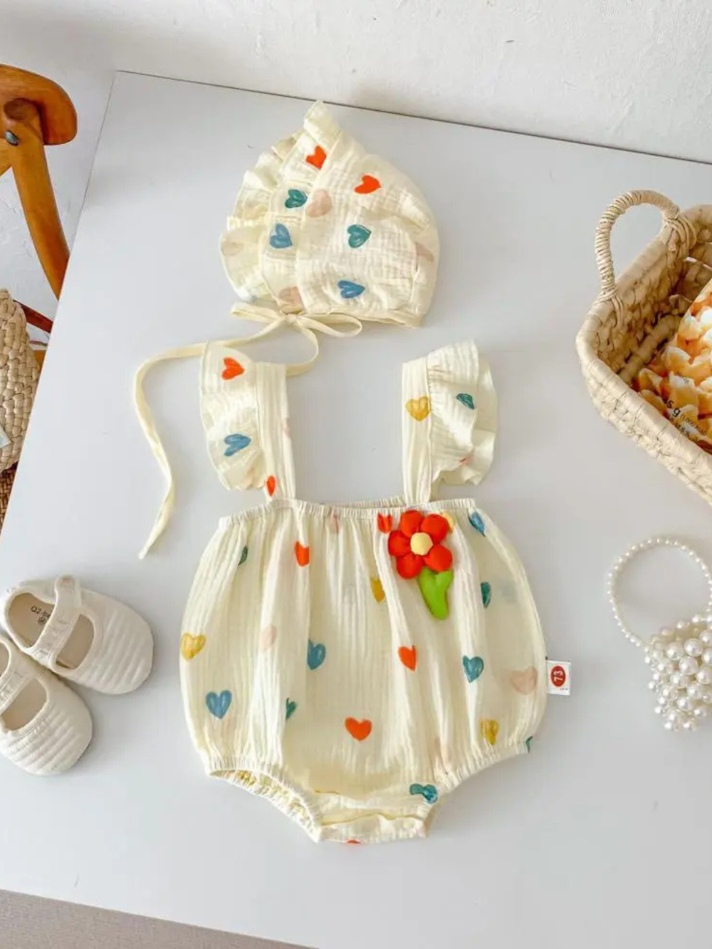 ハート柄ベビースリングロンパースと帽子の2点セット全体（平置き）
