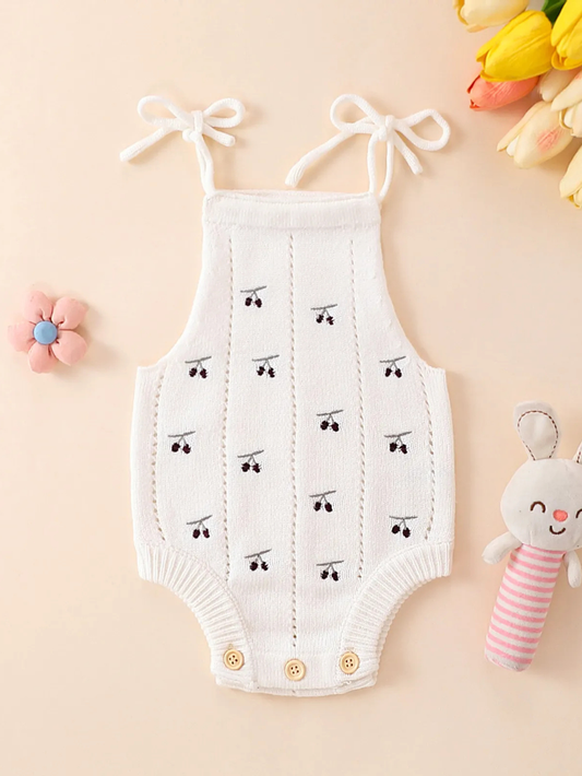 ホワイトのニットベビーロンパース全体（チェリー柄・肩リボン）
