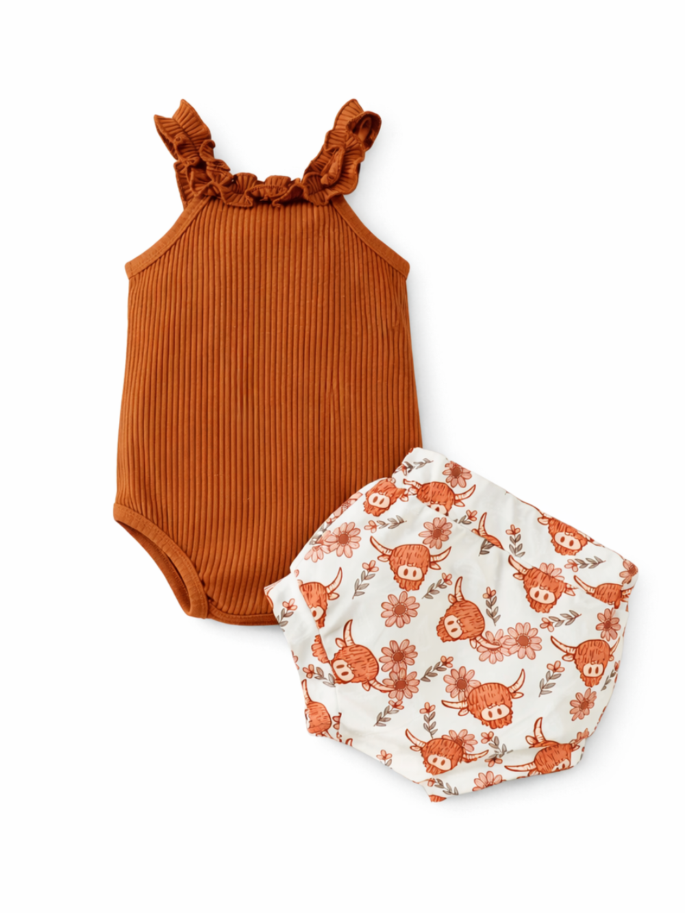 ブラウンのリブ素材フリルストラップ付きベビーボディスーツと、花柄×牛モチーフプリントのブルマを白背景に並べた商品画像。
