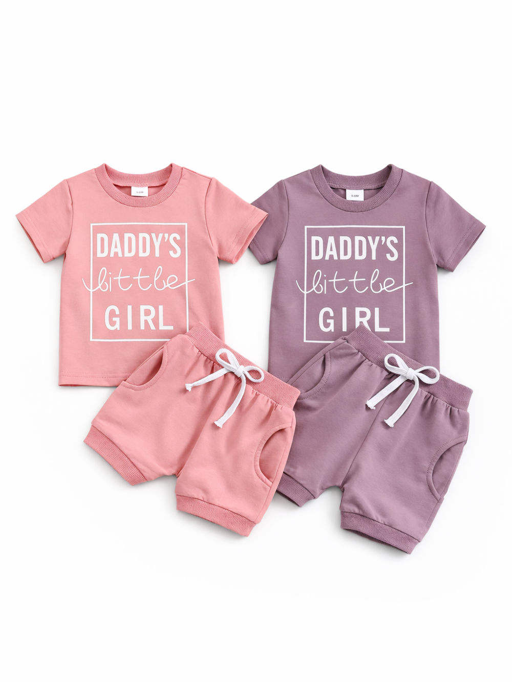 白背景に、ベビー用の半袖Tシャツ＆ショートパンツ2色セット（ピンク／モーブ）を並べた商品画像。各Tシャツは「DADDY’S little GIRL」プリント入りで、パンツは白いドローストリング付き。
