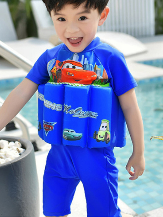 男の子がブルーの浮力付きワンピース水着を着用し、プールサイドで笑顔のシーン
