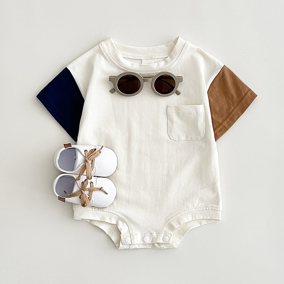 ブルー配色の半袖ボディスーツのフラットレイ
