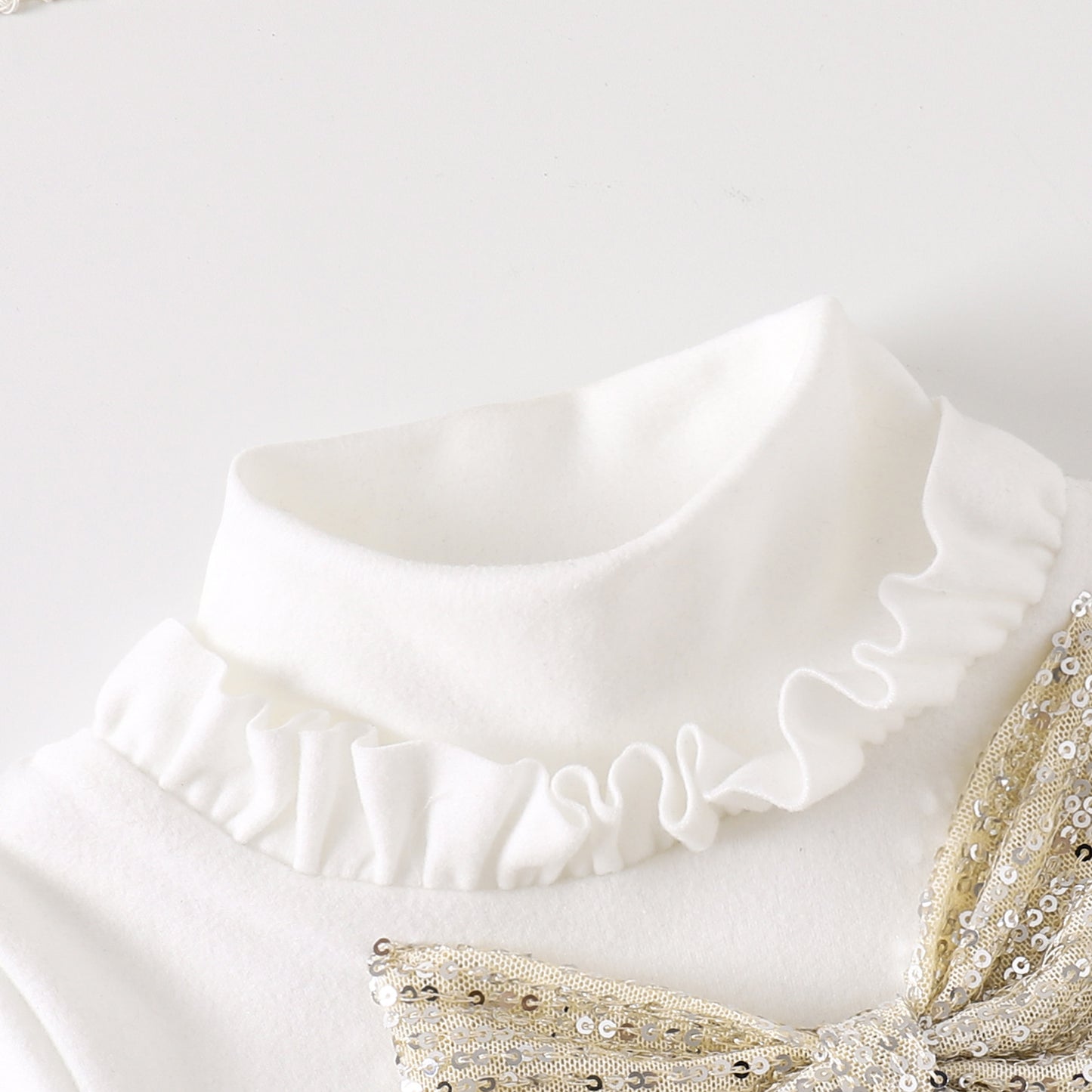 首元のフリルデザインが見える長袖トップスの近接写真
