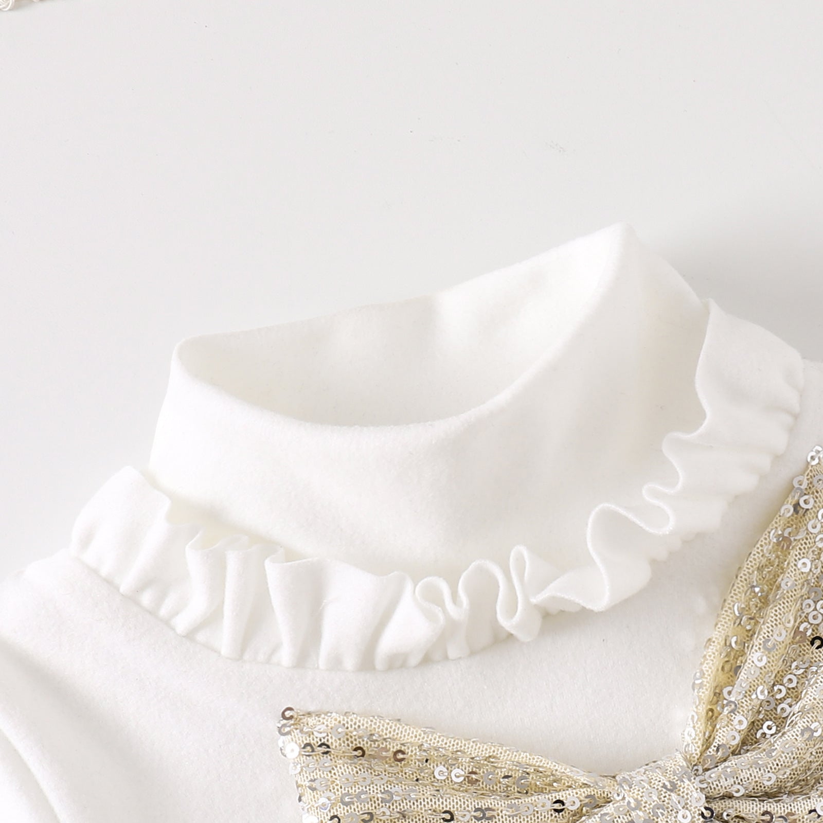 首元のフリルデザインが見える長袖トップスの近接写真
