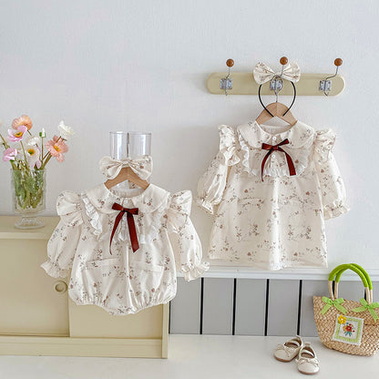 アプリコットリーフ柄のベビーボディースーツ
