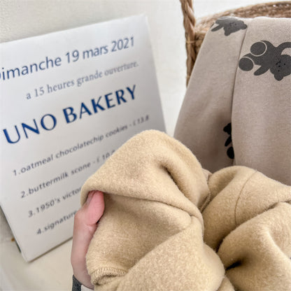 床の上に平置きされたくま柄コットンパンツとトップスを組み合わせたコーデ写真
