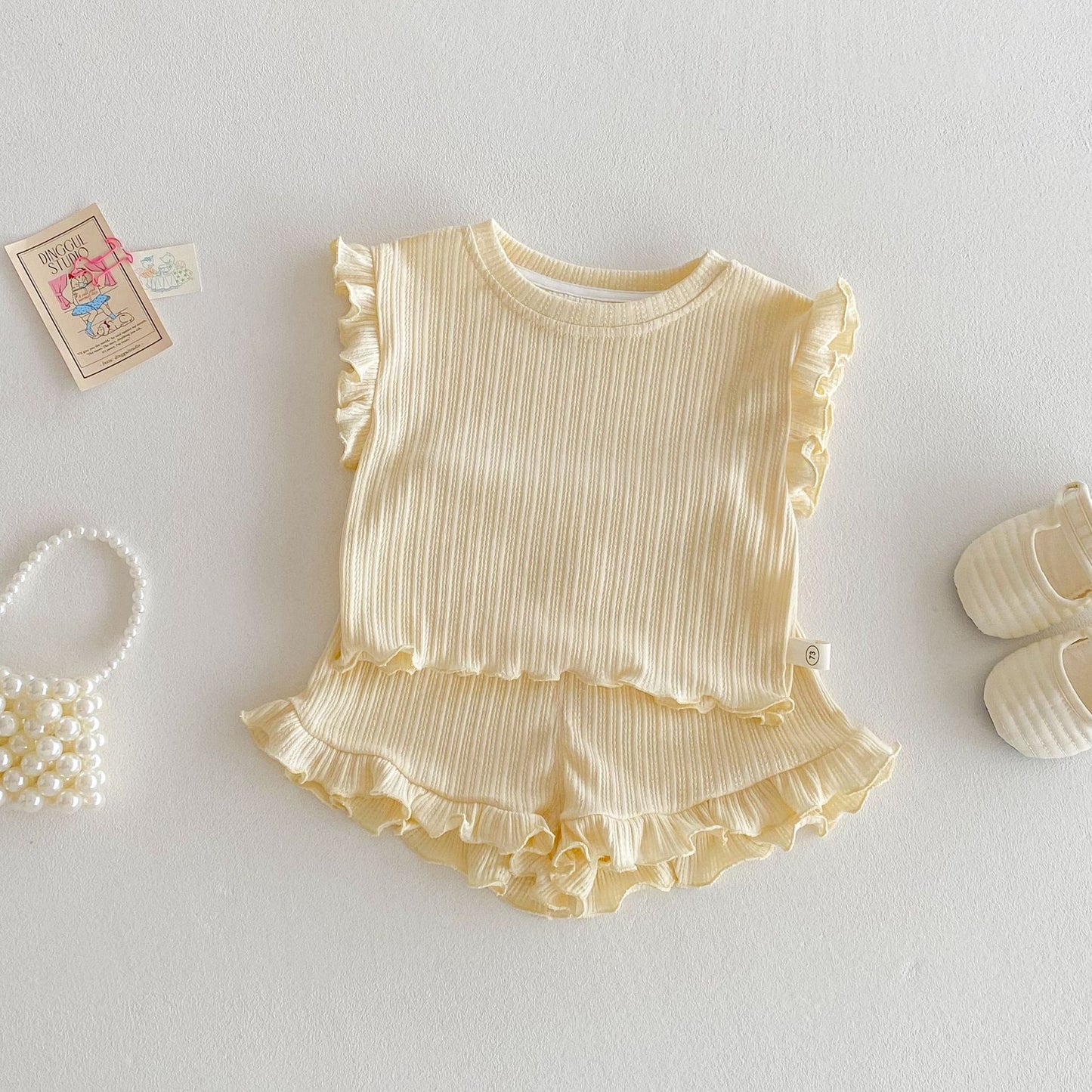 ライトイエローの木耳フリルベストとショートパンツ 上下セット全体
