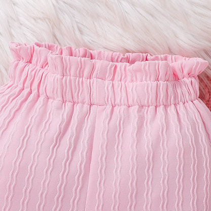 フリル付き長袖トップスとパンツを重ねて置いたベビー女の子コーデ写真
