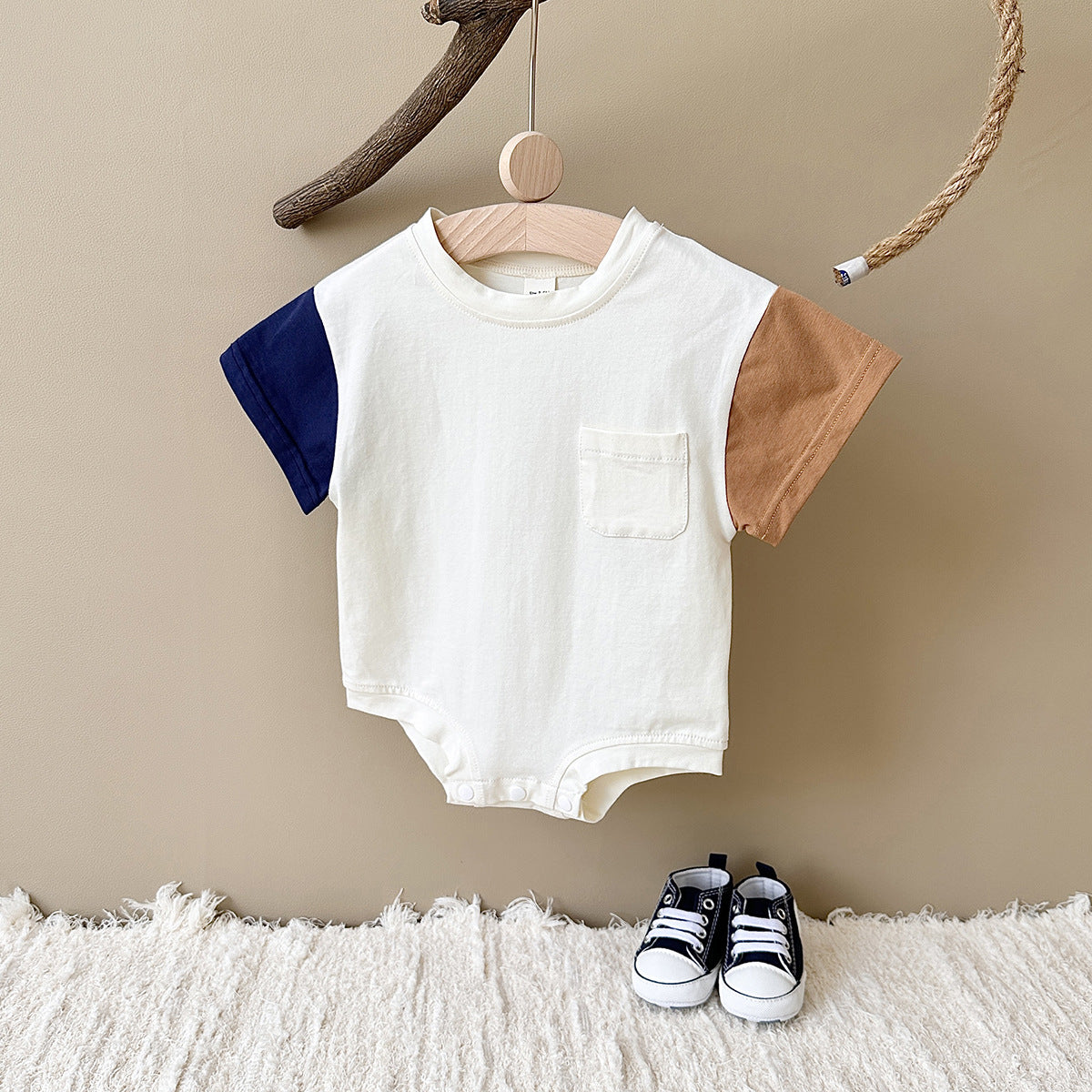 ハンガーに掛けた半袖ボディスーツの全体デザイン
