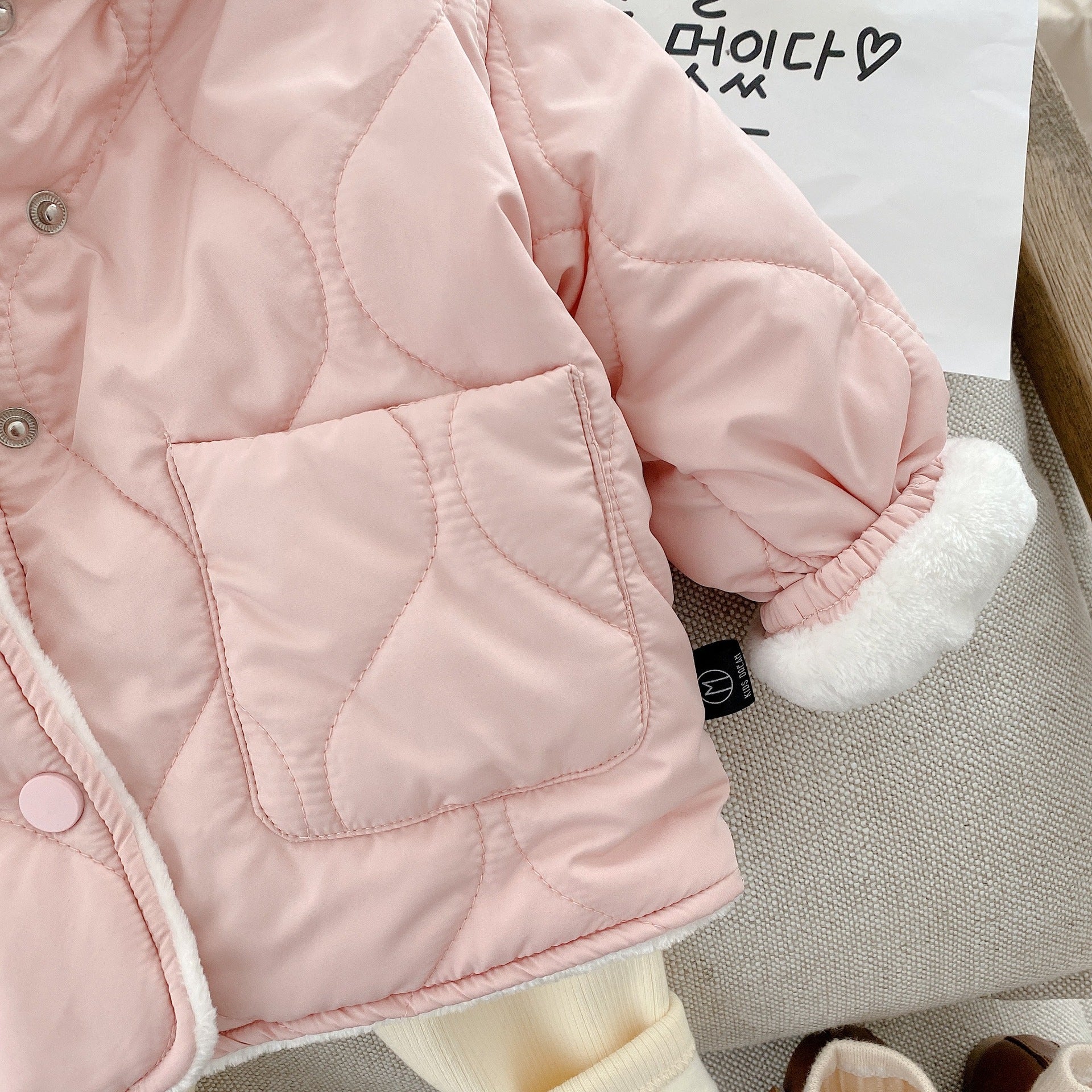 ピンクのキルティングコート前面ポケットのディテール
